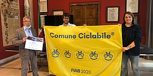 Pozzi Morotti davanti alla bandiera gialla di "Comune ciclabile"