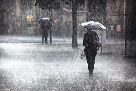 persona con ombrello sotto la pioggia