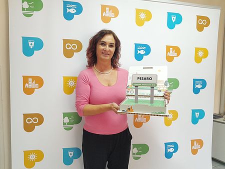 Maria Rosa Conti, assessora alla Sostenibilità mostra il premio "Comune Amico del Bio"