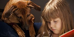 Bambina che legge con cane
