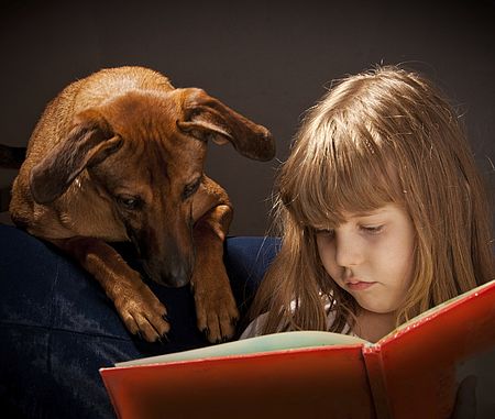 Bambina che legge con cane